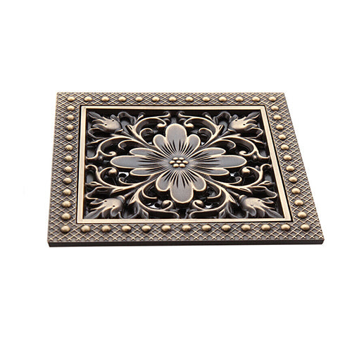 Bronzefarbener Duschablauf mit Blumenmotiv