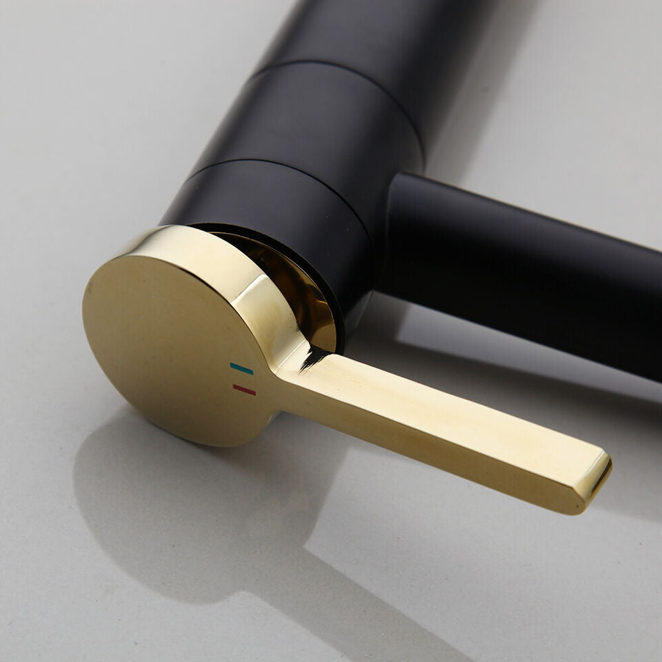 Black washbasin mixer tap with gold-colored elements