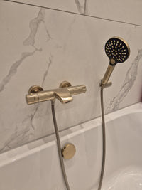 Geborsteld gouden thermostatische badkraan