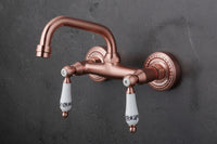 Koperkleurige landelijke muurkraan met keramische handgrepen