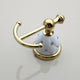 Gold-colored towel hook with white elements